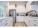 White kitchen features stainless steel appliances and ample counter space at 7410 Barrier Cove Way, Kissimmee, FL 34747