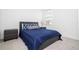 Cozy bedroom with a full-size bed, nightstand and blue bedding at 7410 Barrier Cove Way, Kissimmee, FL 34747