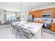 Modern kitchen boasts a large island with seating, stainless steel appliances, and ample cabinetry at 4498 Monado Dr, Kissimmee, FL 34746