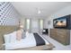 Main bedroom featuring a large bed, TV, and modern dresser at 4498 Monado Dr, Kissimmee, FL 34746