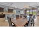 Open concept dining room and kitchen with a large wooden table and access to backyard at 837 Desert Mountain Ct, Reunion, FL 34747