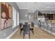 Elegant dining room with a long wooden table and leather chairs, adjacent to a modern kitchen at 837 Desert Mountain Ct, Reunion, FL 34747