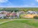 Aerial view of luxury homes with pools, situated on a golf course at 837 Desert Mountain Ct, Reunion, FL 34747