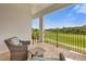 Relaxing balcony with golf course views and wicker furniture at 837 Desert Mountain Ct, Reunion, FL 34747