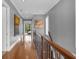 Upstairs hallway with hardwood floors and artwork at 837 Desert Mountain Ct, Reunion, FL 34747