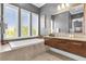 Modern bathroom with soaking tub, floating vanity, and walk-in shower at 837 Desert Mountain Ct, Reunion, FL 34747