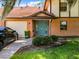 Inviting home exterior with teal front door and landscaping at 100 E Oak Terrace Dr # G1, Leesburg, FL 34748