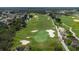 Aerial view of a lush green golf course with sand traps and fairways at 7509 Seven Eagles Way, Reunion, FL 34747