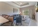 Comfortable living room with L-shaped sofa, large window, and balcony access at 7509 Seven Eagles Way, Reunion, FL 34747