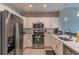 Modern kitchen with white cabinets, stainless steel appliances, and quartz countertops at 7509 Seven Eagles Way, Reunion, FL 34747