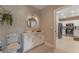 Modern bathroom with white cabinets and a round mirror at 7509 Seven Eagles Way, Reunion, FL 34747