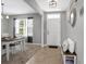 Bright entryway with bench and view into dining room at 209 Sofia Ln, Lake Alfred, FL 33850