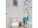 Bathroom with white toilet, tub, and shower with butterfly-themed curtain at 209 Sofia Ln, Lake Alfred, FL 33850