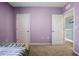 Purple bedroom with two doors and neutral carpet at 209 Sofia Ln, Lake Alfred, FL 33850