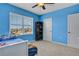 Blue bedroom with a daybed, ceiling fan, and toy shelves at 209 Sofia Ln, Lake Alfred, FL 33850