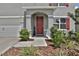 Front entry of house with red door and landscaping at 209 Sofia Ln, Lake Alfred, FL 33850