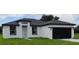 Newly built home with a white exterior, black accents, and a two-car garage at 1300 Hillsborough Ct, Kissimmee, FL 34759