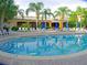Resort-style pool with plenty of lounge chairs and umbrellas at 113 Rogues Retreat, Davenport, FL 33897
