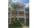 Two-story building with orange exterior, white columns and balconies at 113 Rogues Retreat, Davenport, FL 33897