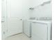 Bright laundry room with washer, dryer, and shelving at 353 River Front Way, Edgewater, FL 32141