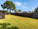 Large backyard with a wooden fence and mature trees at 110 Lindenwood Ln, Kissimmee, FL 34743