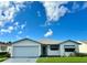 White one-story house with attached garage and manicured lawn at 4901 Pleasant Hollow Trl, Lakeland, FL 33811
