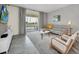 Open living room featuring a gray sectional sofa, accent chairs, and sliding glass doors leading to a balcony at 875 Ocean Course Ave, Davenport, FL 33896
