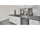 Modern kitchen island with gray countertop, stainless steel appliances, and white cabinets at 875 Ocean Course Ave, Davenport, FL 33896