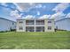 Two-story home with screened balconies and a large grassy backyard at 875 Ocean Course Ave, Davenport, FL 33896
