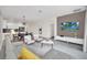 Spacious living room with gray sectional sofa, dining area and open kitchen at 875 Ocean Course Ave, Davenport, FL 33896