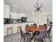 Modern dining area with a wood table, gray chairs, and kitchen view at 875 Ocean Course Ave, Davenport, FL 33896