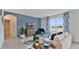 Living room with blue accent wall, beige couch, and a modern media console at 1708 Frogmore Ave, Haines City, FL 33844
