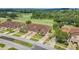 An aerial view of a house with a three-car garage, situated near a lush green golf course at 26841 Bella Vista Dr, Howey In The Hills, FL 34737