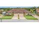 Tan two-story home with double garage and manicured lawn at 26841 Bella Vista Dr, Howey In The Hills, FL 34737