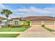 Exterior view of a house with a three-car garage, palm trees, and well-maintained landscaping at 26841 Bella Vista Dr, Howey In The Hills, FL 34737
