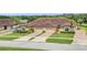 Aerial view of a two-story house with a three-car garage and a manicured lawn at 26841 Bella Vista Dr, Howey In The Hills, FL 34737