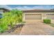 Exterior view of a three car garage with brick driveway at 26841 Bella Vista Dr, Howey In The Hills, FL 34737