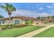 Exterior of a house featuring a three-car garage, lush landscaping, and a brick driveway at 26841 Bella Vista Dr, Howey In The Hills, FL 34737