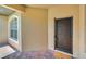 Front entryway with a dark brown door and brick flooring at 26841 Bella Vista Dr, Howey In The Hills, FL 34737