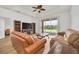Living room with leather sofas, a large TV, and access to a patio at 26841 Bella Vista Dr, Howey In The Hills, FL 34737
