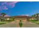 Tan two-story home with double garage and manicured lawn at dusk at 26841 Bella Vista Dr, Howey In The Hills, FL 34737