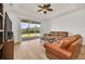 Living room with leather couches and sliding doors leading to backyard at 26841 Bella Vista Dr, Howey In The Hills, FL 34737