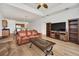 Spacious living room featuring leather sofas, wood flooring, and a large flat-screen TV at 26841 Bella Vista Dr, Howey In The Hills, FL 34737