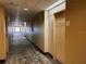 Long hotel hallway with carpeted floor and doors to rooms at 7601 Canada Ave # 605, Orlando, FL 32819