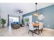 Bright dining room with a wood table and six white chairs adjacent to the living room at 951 Splash Shot Pl # 0, Davenport, FL 33896