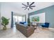 Spacious living room with gray sofa, blue accents, and access to a balcony at 951 Splash Shot Pl # 0, Davenport, FL 33896