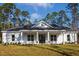White farmhouse exterior with a covered porch and landscaped yard at 6979 Big Bend Dr, St Cloud, FL 34771