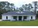 White farmhouse with a covered porch and rocking chairs at 6979 Big Bend Dr, Saint Cloud, FL 34771