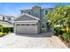 Two-story house with gray siding, shutters, and a paver driveway at 7443 Marker Ave, Kissimmee, FL 34747