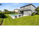 Private backyard with pool, spa, lounge chairs, and grassy lawn at 7443 Marker Ave, Kissimmee, FL 34747